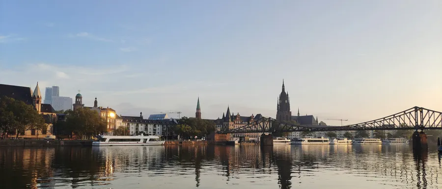 Flussufer mit einer Stadtsilhouette im Abendlicht